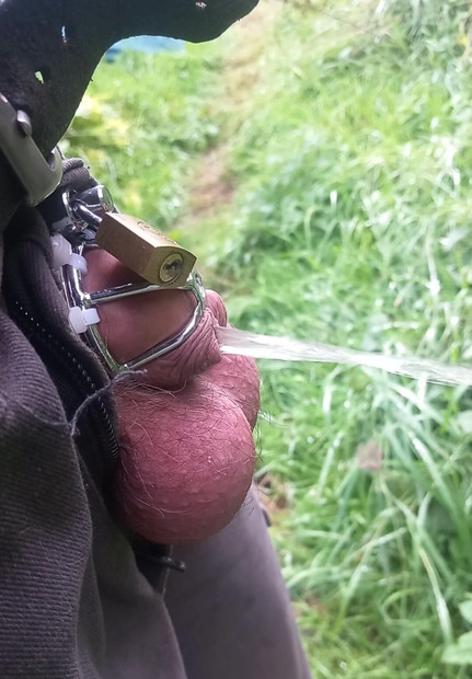 Cuckold with helpless small cock and chastity cage pisses outdoors