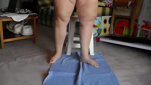 Jen sitzt auf einem stuhl und pinkelt auf ein handtuch auf dem boden