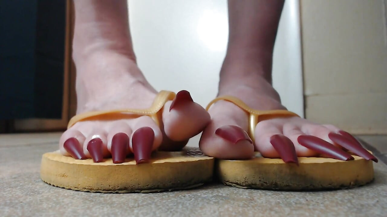 Toenails hanging off yellow flip flops