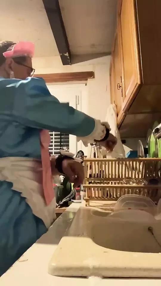 In a blue maid's outfit with pink bows to do the dishes.