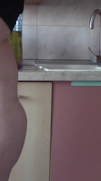 Stunning moment from "Sexy wife having fun in the kitchen with roses. Sexy naked wife preparing food in the kitchen."