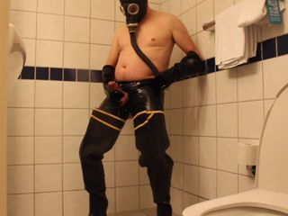 Rubbergloved masturbarse en la ducha del hotel usando botas