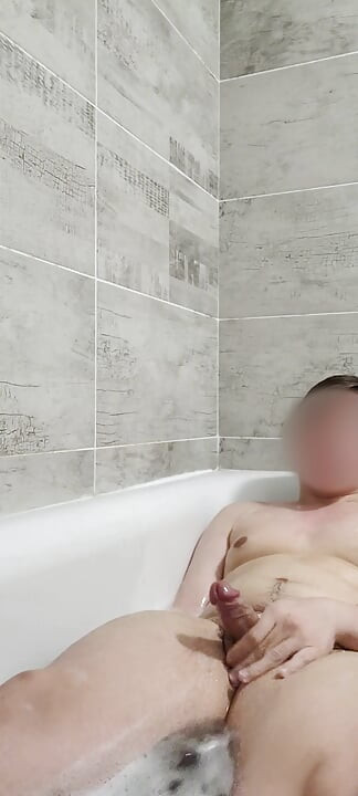 Teenie-junge spielt in der badewanne und zeigt füße