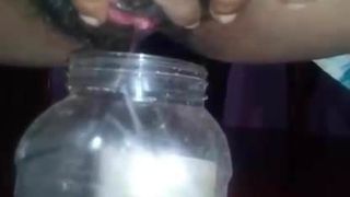 Menina do Sri Lanka mijando em uma garrafa