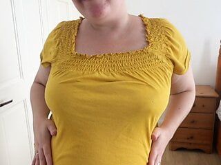 Tímida madrastra posando y desnudándose en pantalones cortos ajustados y camisa amarilla ajustada