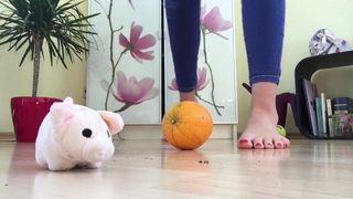 Schiaccia i piedi arancioni schiacciando i piedi nudi di feticcio