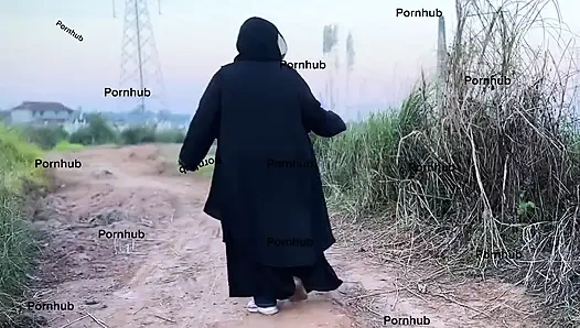 Gadis petani mesir dengan abaya mencoba menemukan timun di lahan pertanian untuk memeknya