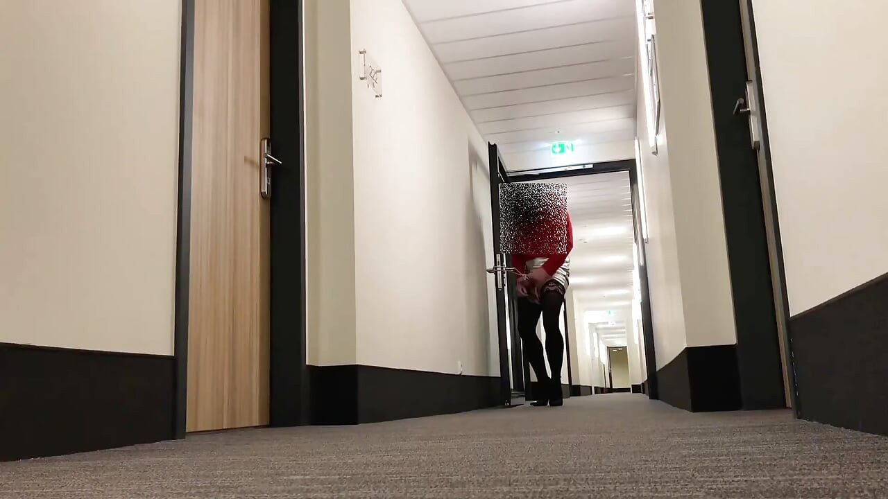 Crossdresser odsłaniający na hotelowym korytarzu