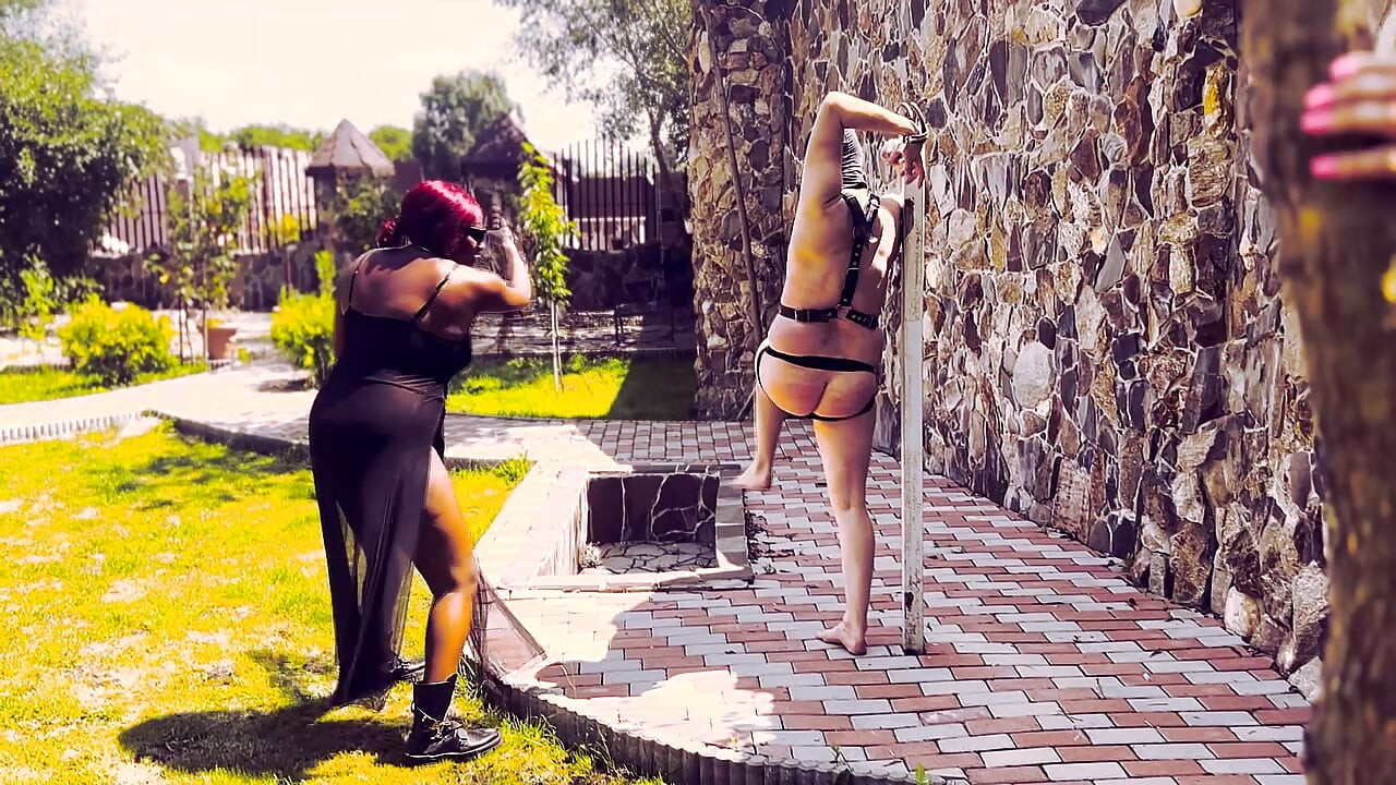 Boze zwarte dominatrix zweepslagen met slaaf