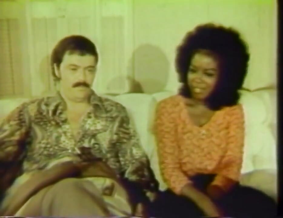 Une chatte noire et blanche se fait lécher dans la chambre