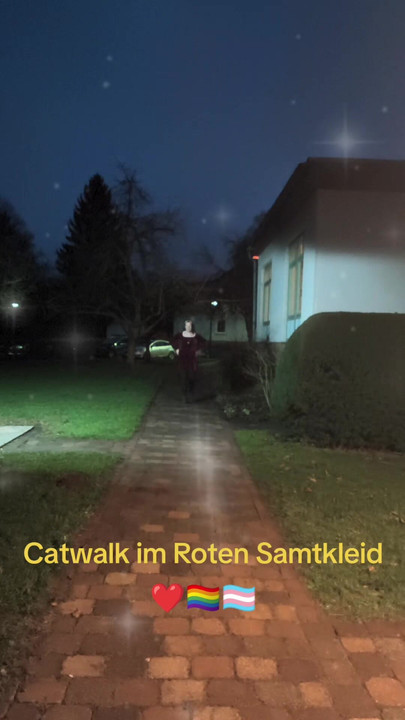 赤いベルベットのドレスでランウェイを歩く。