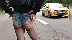camina por la ciudad y solicitación en la carretera de una mariquita con traje de puta, top de vinilo y mini pantalones cortos de mezclilla