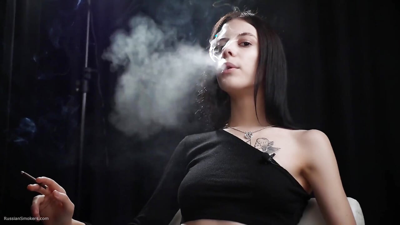 Une nana mince fume un rouge
