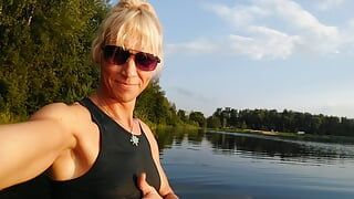 Schwimmen auf dem see in sportbekleidung bei sonnenuntergang .. Nasse leggings und t-shirt...