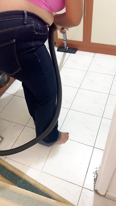 Kurvete kvinne som vasker huset i bukser