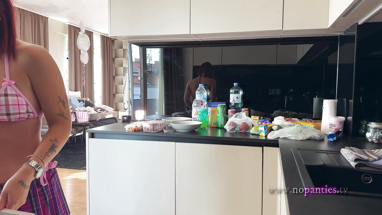 真正的避暑别墅女大学生在厨房里准备一些水果，穿着最小的比基尼，穿短裙