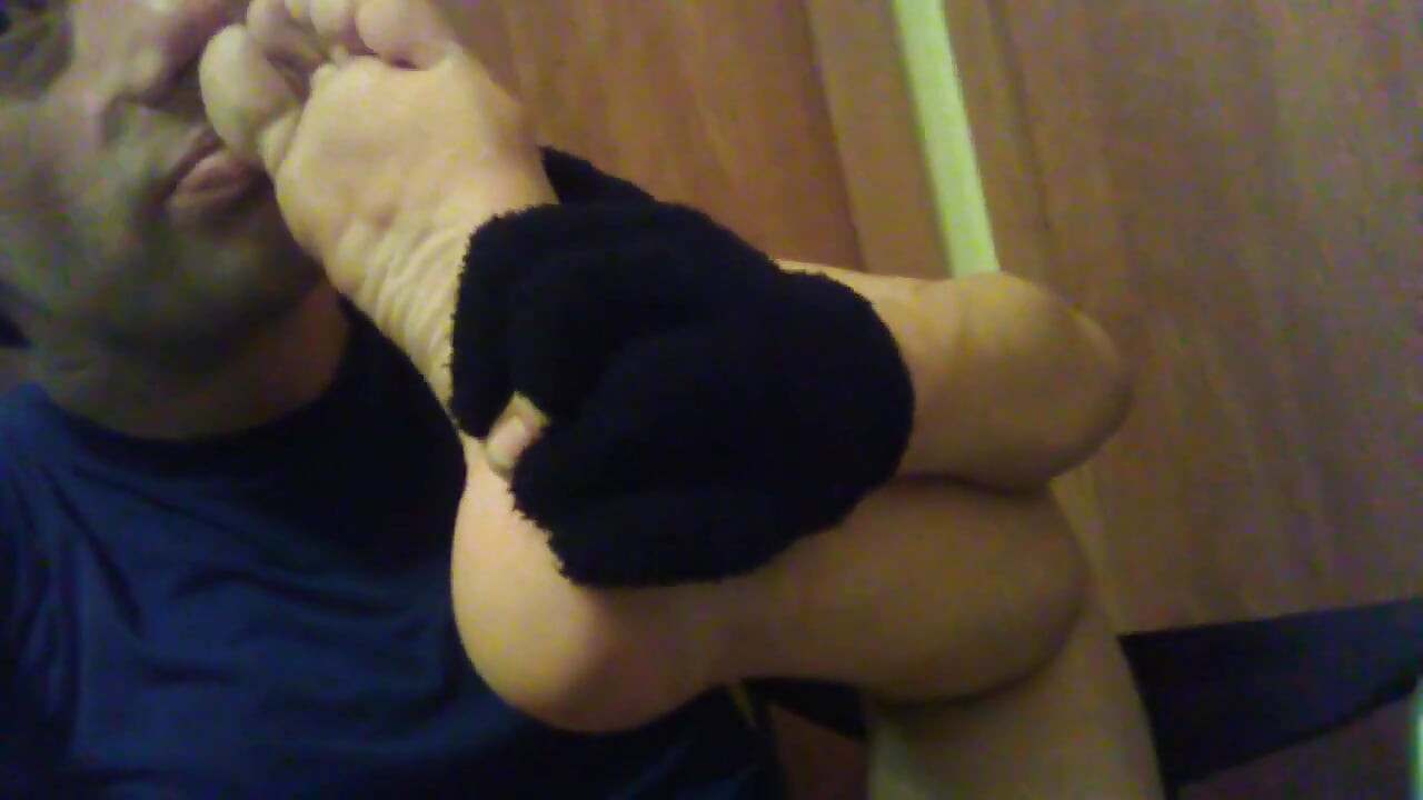 Meine schmutzigen füße und socke zu gesicht und mund schnüffeln und berühren