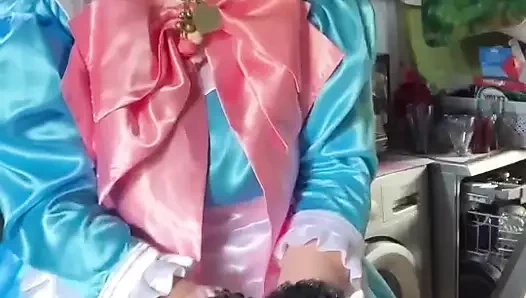 Çamaşır yıkamak için pembe yaylı mavi bir hizmetçi kıyafeti içinde.