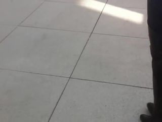 Wanita mencoba sepatu bot paha tinggi di depan umum