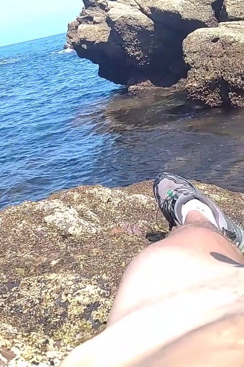 Einen großen harten schwanz abwichsen mit Blick auf das Meer in der Strandbucht, bis er kommt