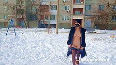 Marimacho desnuda con un abrigo de piel se balancea en un columpio en invierno
