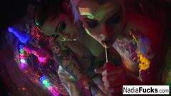 Black-light babes Nadia and Ophelia suck off a colorful cock