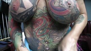 Fortemente tatuada e com piercing, motociclista viúva negra chupa