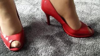 Жена моделирует в красных каблуках с открытым носком другой женщины