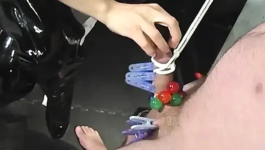 BDSM-herrin in schenkelhohen seilt das gesicht des typen mit halsband und zieht seinen gefesselten schwanz