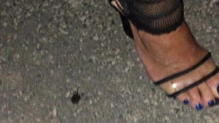 На улице с сексуальными синими пальцами ног в прозрачных каблуках и в сетчатом комбинезоне в сеточку