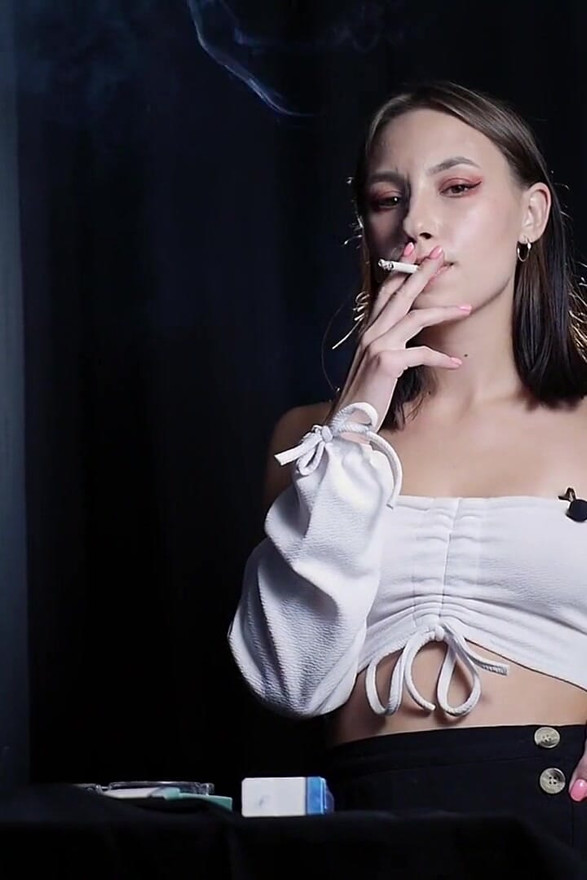 Elegant Brunette Smoking Cigarette in Dark Studio Scene