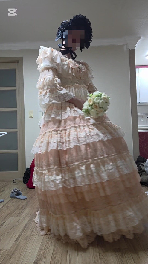 A man dressed as a woman dances in a dress.