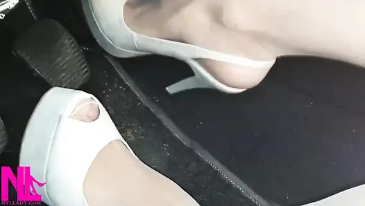 Revving und verrücktes Pedalpumpen in weißen strümpfen und weißen sandalen mit hohem absatz,