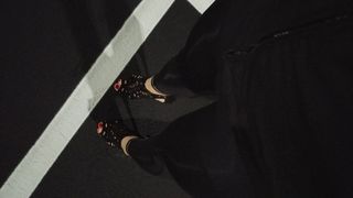 Alışveriş merkezinin otoparkında topuklu ayakkabılarla yürümek kırmızı ayak tırnakları