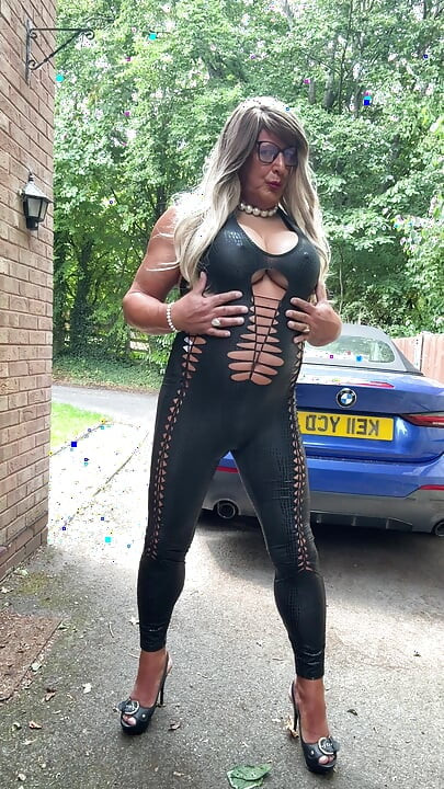 Si seksi crossdresser kellycd2022 dengan kostum catsuit dan sepatu hak tinggi pvc hitam
