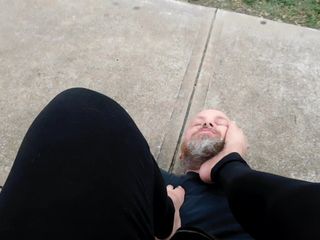 Bresha beijando os pés e adorando em parque público