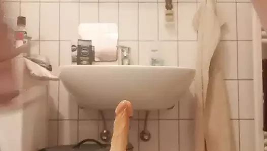 Tranny jerks off with a dildo in her ass in the bathtub
