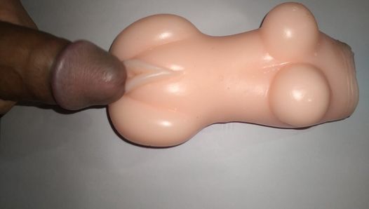 Une poupée sexuelle se caresse la bite.