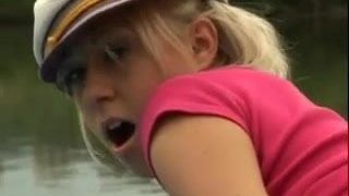 Une fille en bottes baise sur un bateau