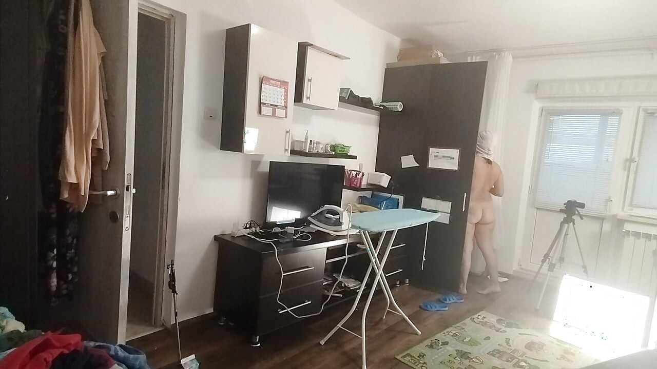 Seksowna brunetka robi nagie prace domowe w domu