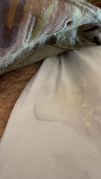 Close-up van het sperma dat overbleef van een soldaat die zich in uniform op een jockstrap aftrekte