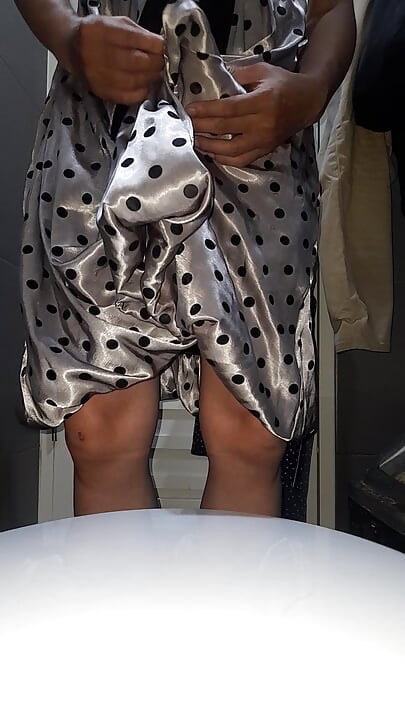 Crossdresser nosi satensku svilenu haljinu na točkice sa svilenkastom podstavom