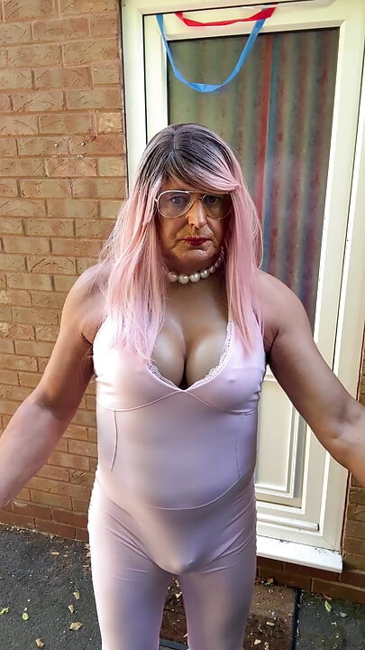 Crossdresser kellycd2022 u ružičastom kombinezonu i štiklama