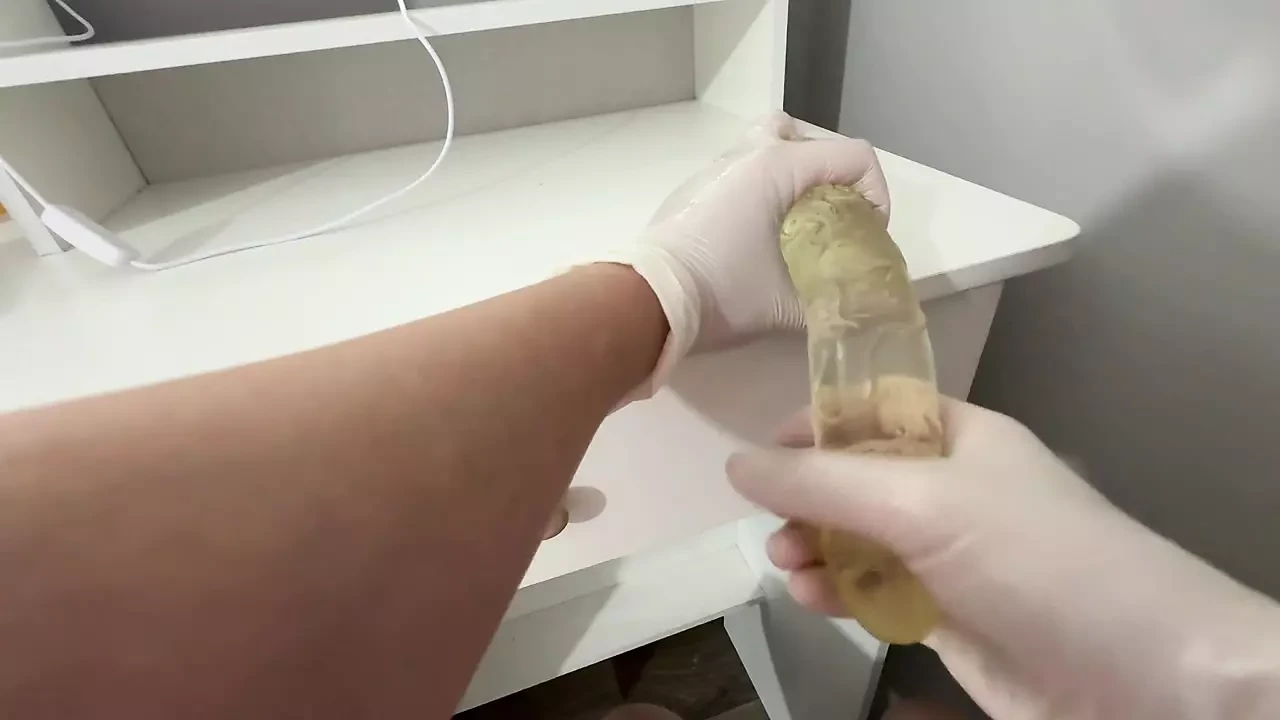 Je fais une branlette au gode avec les mains huileuses dans des gants blancs médicaux