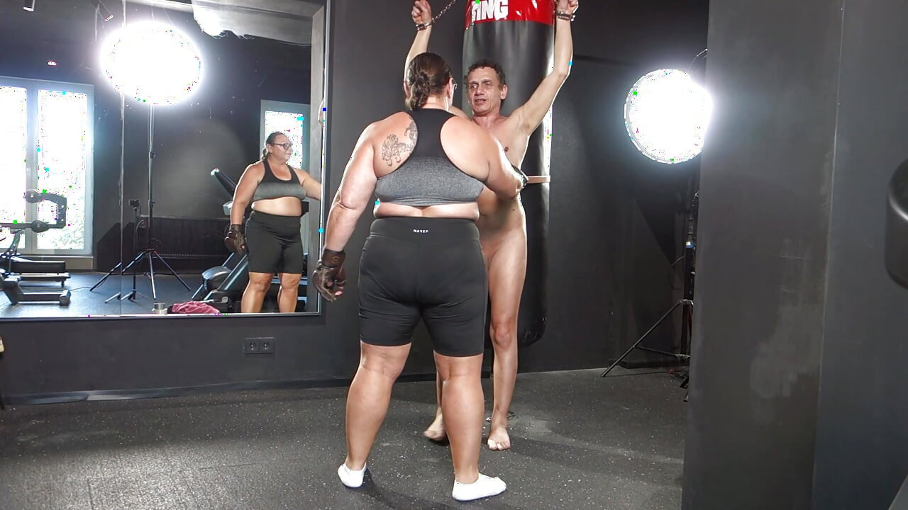 Mistress April practices boxing on a human punching bag.