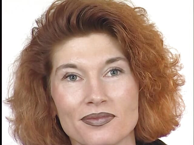 Tattooed ginger milf is filling her pussy with a big dildo