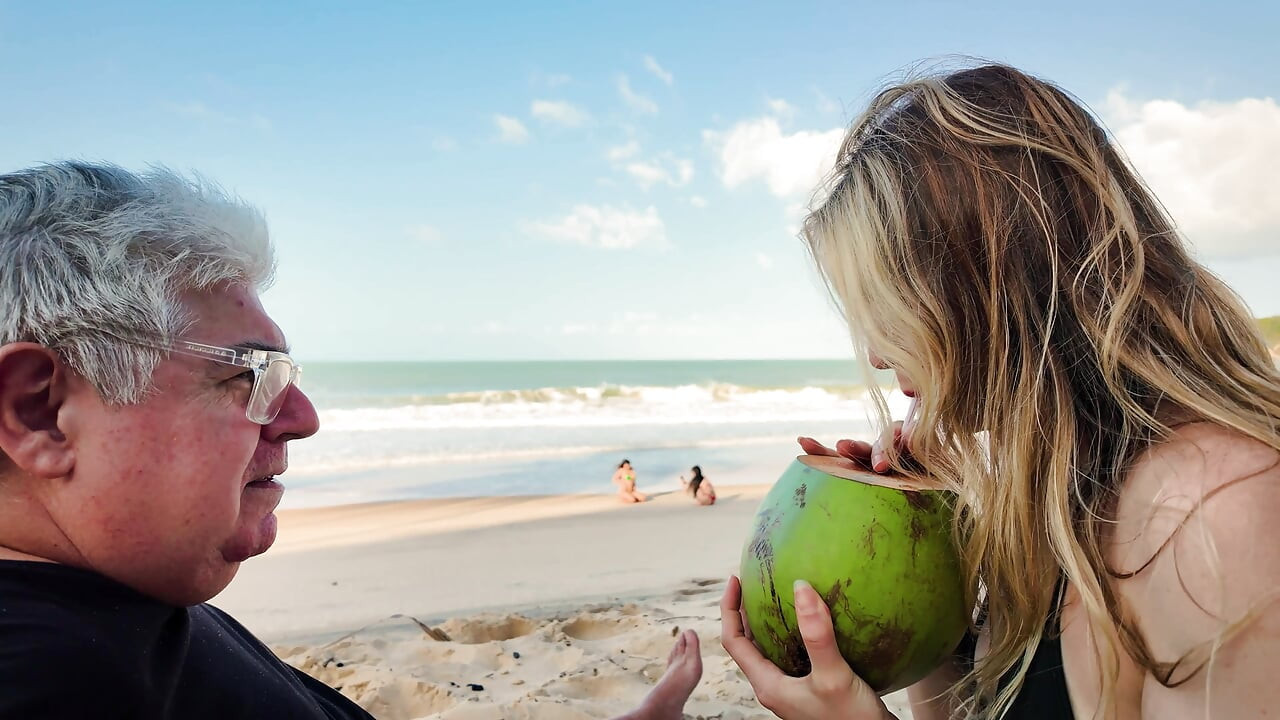 Cer un cuplu din Caraibe o nucă de cocos și o pe femeie în timp ce soțul se duce să o ia.