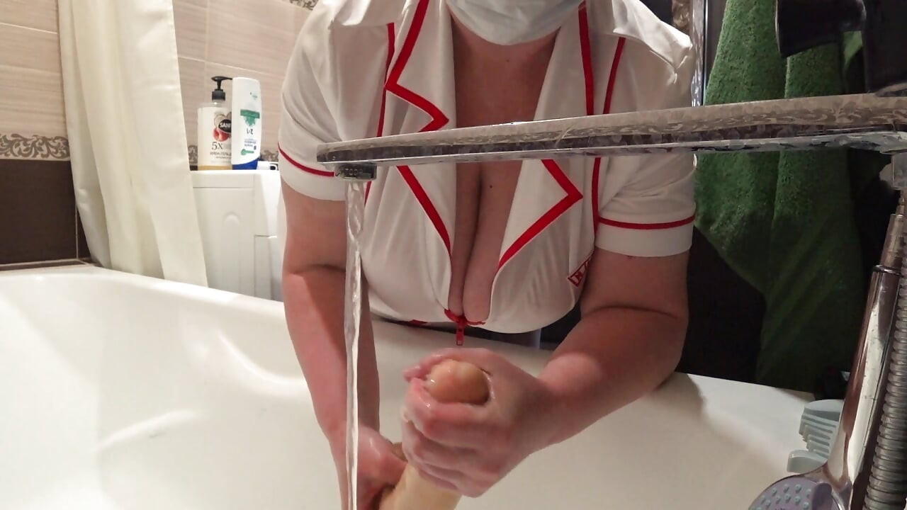 Big Boobs. Gorgeous Cleavage Under a Medical Gown. a Mature Nurse on Camera at Work