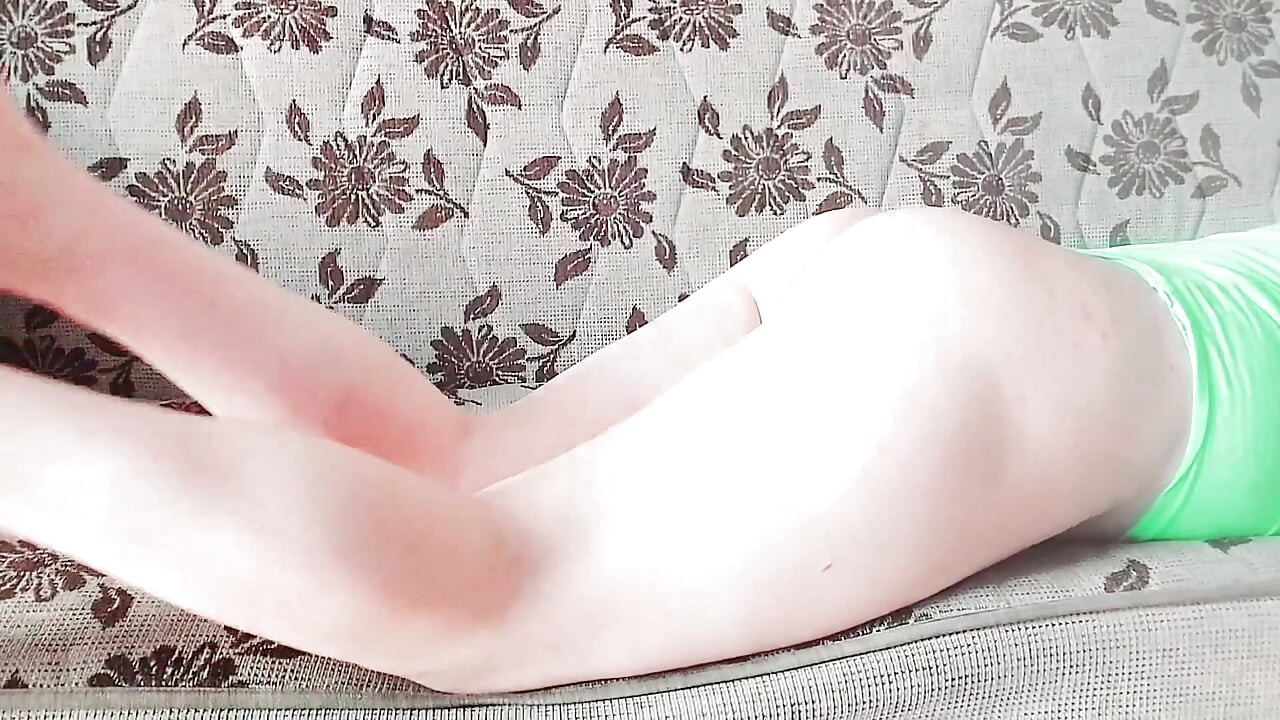 Prekrasan femboy u svilenoj haljini pod toplim svjetlima