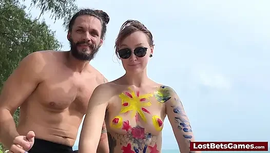 A horny couple playing strip tic tac toe on the beach